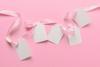 overhead-view-blank-tags-pink-ribbon-against-plain-pink-backdrop
